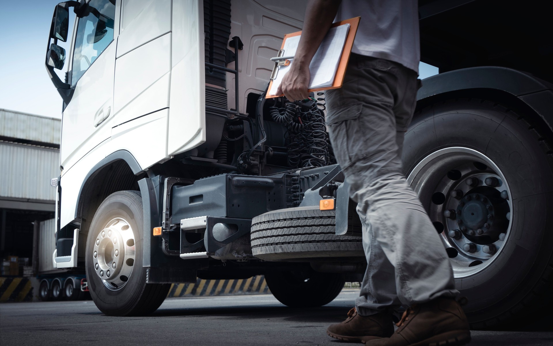 Truck Driver is Checking the Truck's Safety Maintenance Checklist. Lorry Fixing. Truck Inspection Safety of Semi Truck Wheels Tires.