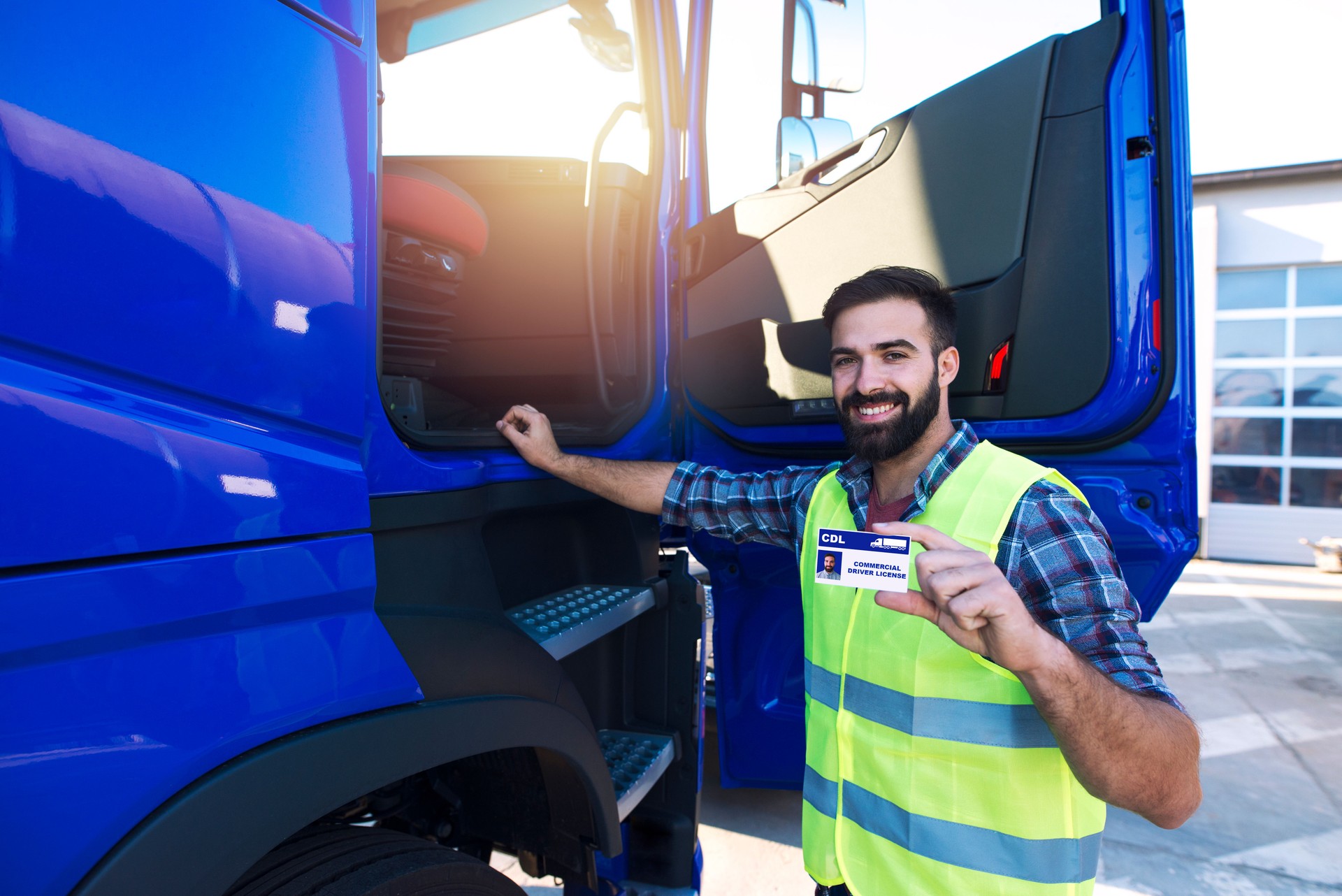 Truck driver candidate showing CDL driving license. Successfully passed training driving exam.